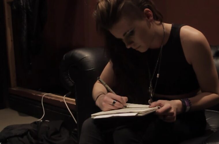 Lynn Gunn of Pvris writing while shrouded in the kind of moody darkness that defines so much of her music and the literature you study.
